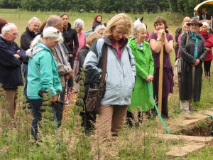 heads bowed group at grave